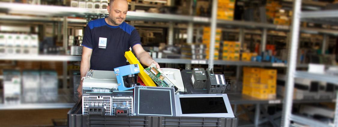 UNIS Group employee sorting industrial electronic equipment for recycling in a warehouse.
