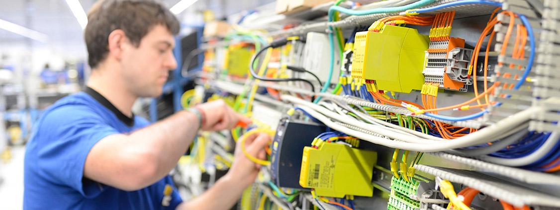 Technician carrying out on-site maintenance on industrial electrical control equipment