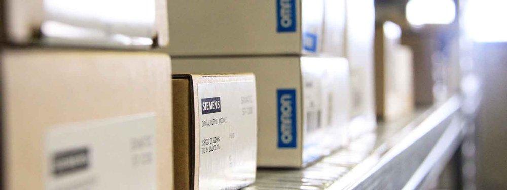 Siemens electronicd in labeled boxes stored on a warehouse shelf.